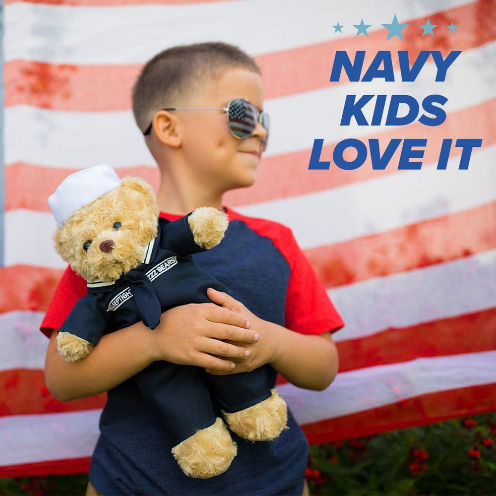 A child holds the Navy Teddy Bear Personalized Bundle by ZZZ BEARS in front of a blurred American flag. "NAVY KIDS LOVE IT" appears in blue and gold with blue stars—perfect as a Navy family gift.